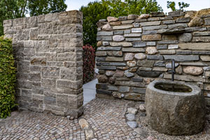 Rustikale Natursteinmauern in Kombination mit einer grünen Hecke eignen sich perfekt als Sichtschutz für Ihren Garten.