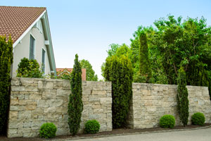 Natursteinmauern und Holzbauten sind die beliebtesten Alternativen für nachhaltigen Sichtschutz in Ihrem Garten.