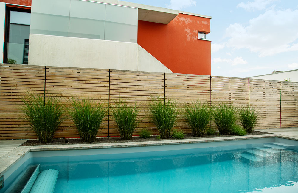 Die Anschaffung eines Pools für den eigenen Garten beinhaltet oft auch die Installation eines Sichtschutzes.