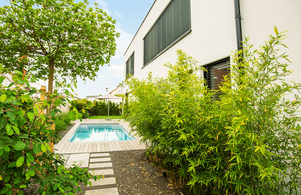 Zwischen Bäumen und Sträuchern kommt Ihr einzigartiger Pool im Garten besonders zur Geltung.